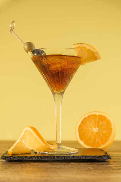 透明玻璃杯中的红色酒精鸡尾酒，木桌上放着柑橘和橄榄图片下载