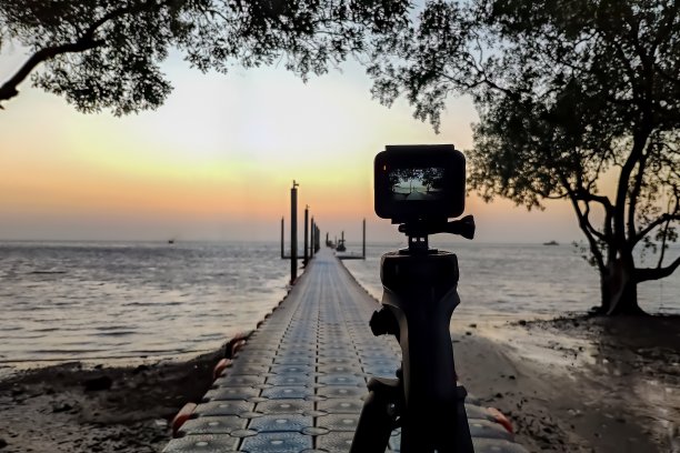 安装在三脚架上的照相机拍摄了码头和日出图片下载