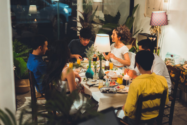 亚洲人群朋友在家里吃饭，他们很乐意交谈。图片下载