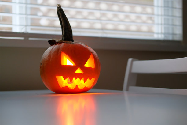 万圣节的庆祝标志，南瓜在厨房的桌子上发光图片下载