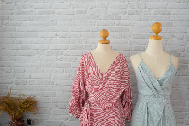 化妆间白色砖墙纹理背景上的彩色礼服。图片下载