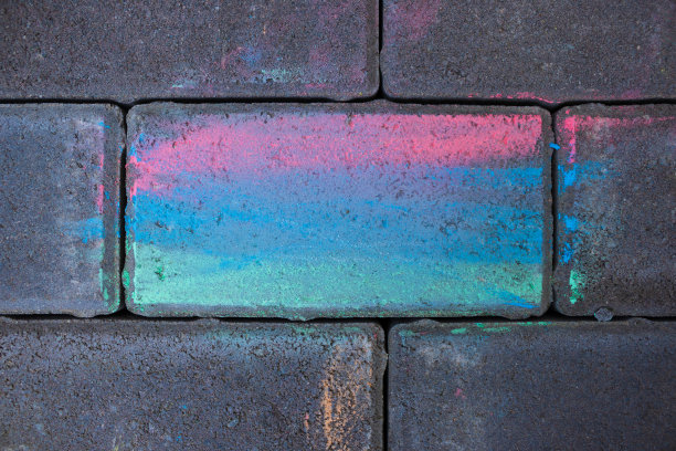 用彩色粉笔涂的铺路石。多色的石头。图片下载