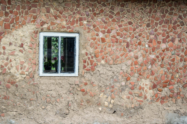 锈迹斑斑的墙上挂着鲜花的旧窗，乡村景色，复古的纹理背景图片下载