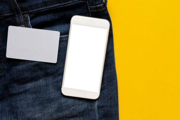 空白信用卡和智能手机的特写顶部视图与剪切路径隔离白色屏幕(你可以添加内容)在现代牛仔牛仔在黄色背景与复制空间设计的时尚生活方式时尚概念图片下载