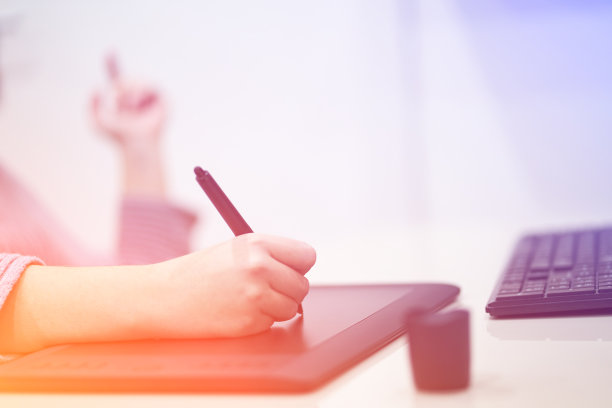 特写手的女性插画设计师，握笔和绘画在电脑图形板。自由的概念。图片下载