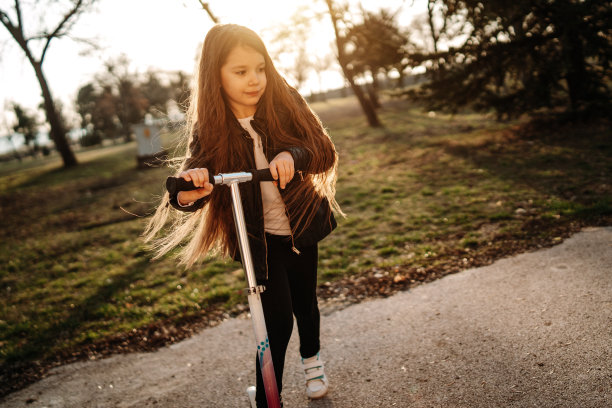 可爱的女孩在公园里骑摩托车图片下载