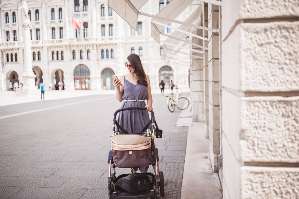 年轻的母亲带着她的孩子走在城市里图片下载