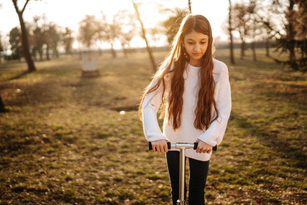 可爱的女孩在公园里骑摩托车图片下载