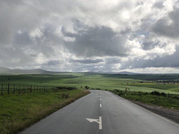 穿过绿色农田通往山下的路图片下载