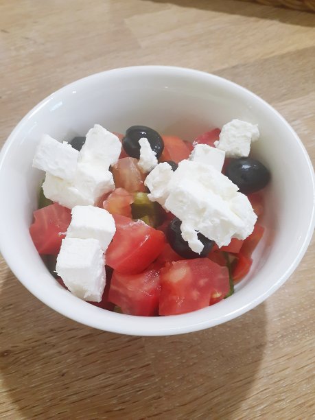 桌上的白碗里盛着希腊沙拉图片下载