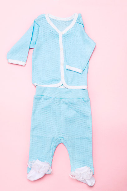 粉红色背景的蓝色婴儿衣服，粉红色背景的衬衫、裤子和白袜子。儿童设计夏季时装。平躺图片下载