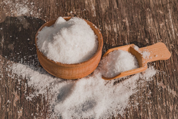在一张旧木桌上用木勺撒盐，图片下载