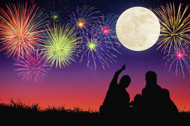 幸福的一家人坐在山上看月亮和烟花。庆祝中秋节图片下载