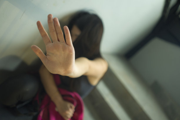 遭受欺凌而痛苦的悲伤亚洲少女。年轻漂亮的中国女大学生坐在校园楼梯上，成为虐待的受害者，感到害怕和孤独，受到骚扰和欺凌图片下载