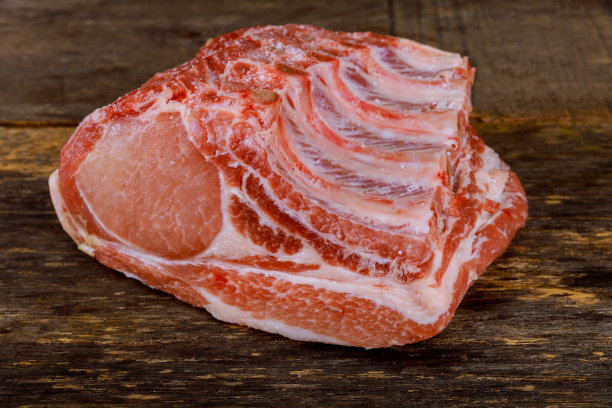 生猪肉孤立在木制背景。图片下载