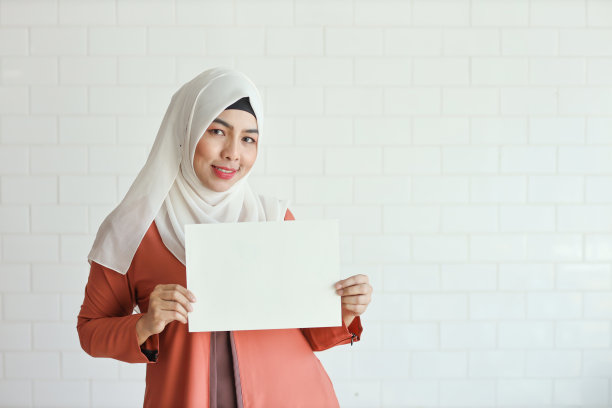 年轻的穆斯林女商人展示空白白纸并指向它图片下载
