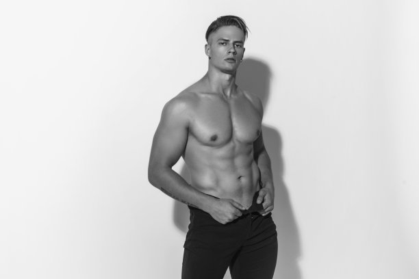 肌肉强壮美丽的剥离男性模特在牛仔黑牛仔裤上白色孤立的字体背景图片下载