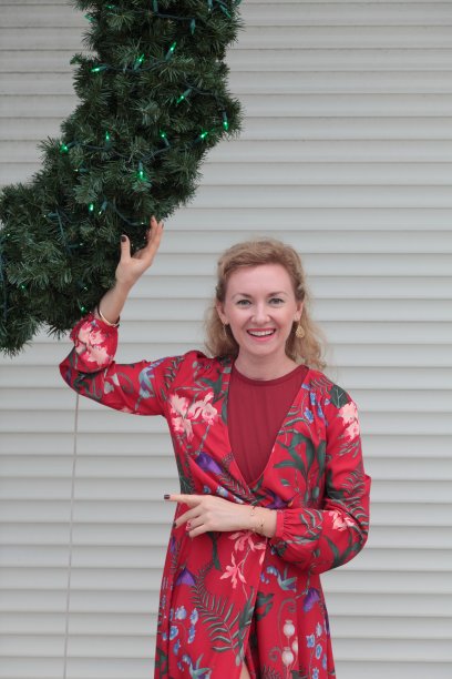 在圣诞花环前穿着红色衣服的女人图片下载