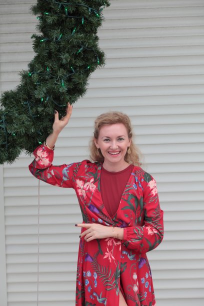 在圣诞花环前穿着红色衣服的女人图片下载