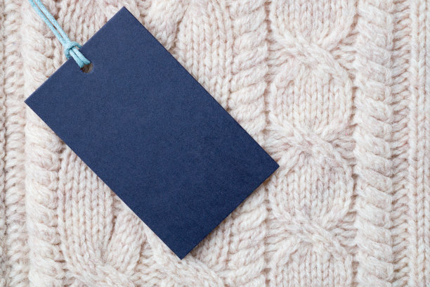 针织羊毛衣服背景上的空白纸标签图片下载