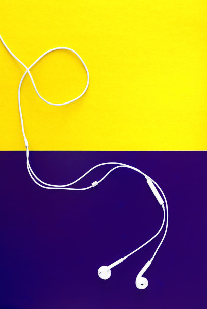 黄紫罗兰背景的白色耳机。从以上观点。图片下载