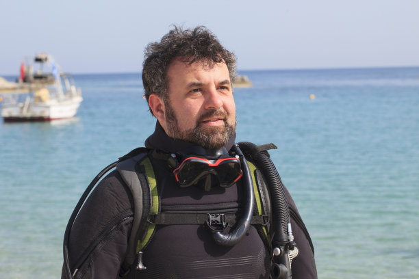 技术潜水。水上运动。英俊的潜水员准备去潜水。运动的男人。美丽的蓝色海洋在背景。图片下载