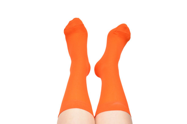 橙色袜子上的女人脚孤立在白色的背景。图片下载