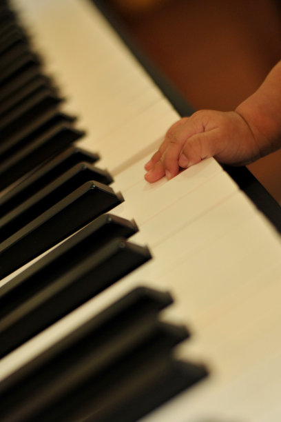 手小的儿子弹钢琴，孩子的钢琴键盘-形象图片下载