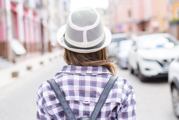 背包背包绑带休闲度假阳光搭便车概念。后面的背影近距离观看照片肖像美丽的现代漂亮的少年走在空旷的街道模糊的背景图片下载