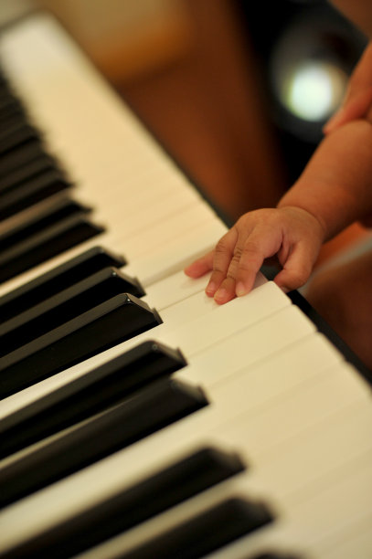 手小的儿子弹钢琴，孩子的钢琴键盘-形象图片下载