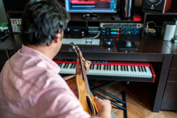 一个在录音棚里弹吉他的男人图片下载