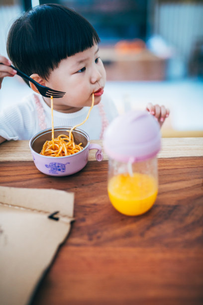 亚洲小女孩，两岁的小女孩在家里吃面条。图片下载