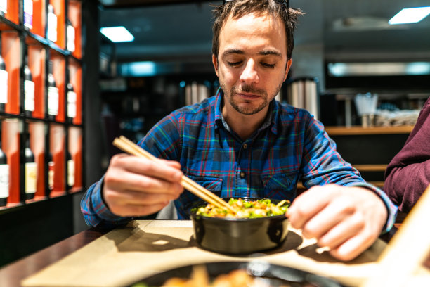 一个男人在餐馆吃美味的中国菜图片下载
