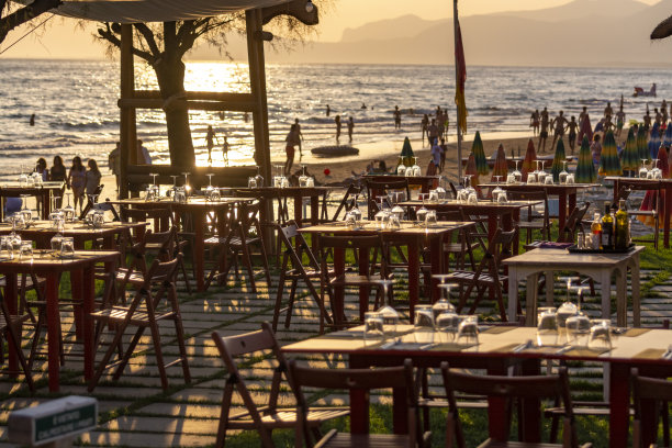 户外咖啡厅或餐厅提供晚餐在拥挤的海滩与海景，夏季假期图片下载