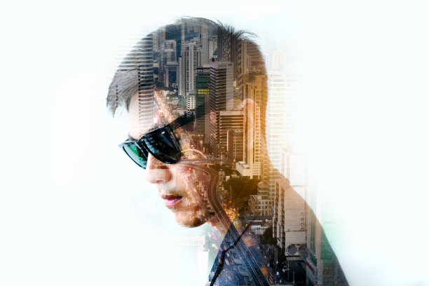 精明的商人站着，穿着西装制服。对城市景观的双重曝光。图片下载