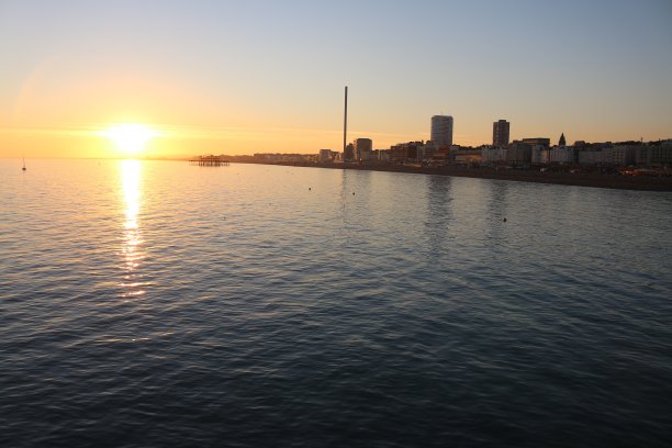 布莱顿，东苏塞克斯，英国，从布莱顿码头，黄昏照片的布莱顿海滩，遥远的i360观察塔和西码头日落的图像和城市沿海天际线图片下载