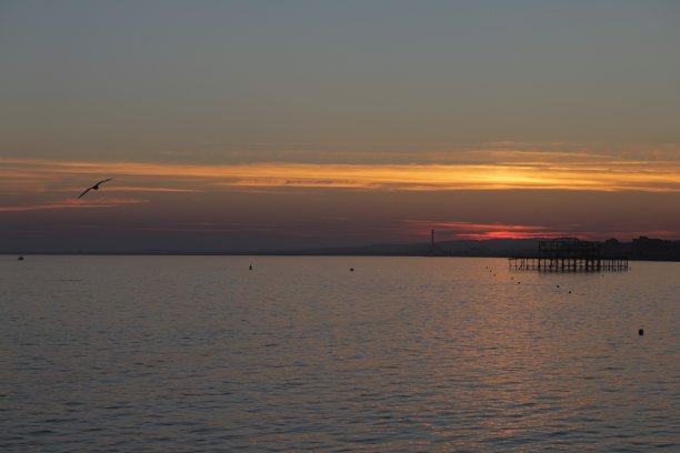 布赖顿西码头与戏剧性的日落天空在海上和城市沿海天际线布赖顿，东苏塞克斯，英国，从布赖顿码头，布赖顿海滩的黄昏照片图片下载