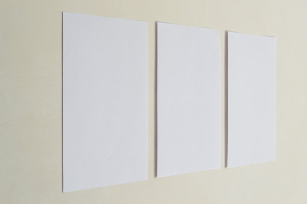 三张白纸贴在米黄色的墙上。图片下载