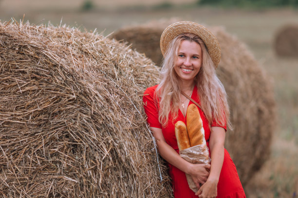 迷人的女孩在草堆里笑。图片下载