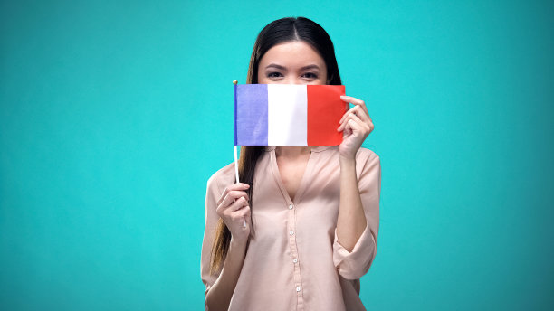 女孩用法国国旗遮住脸，学习语言，学习教育和旅行图片下载