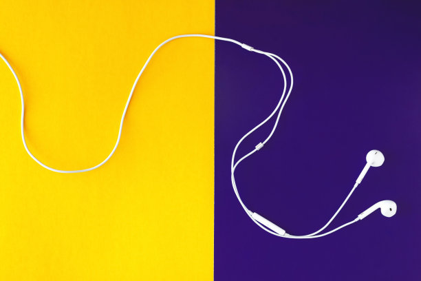 黄紫罗兰背景的白色耳机。从以上观点。图片下载