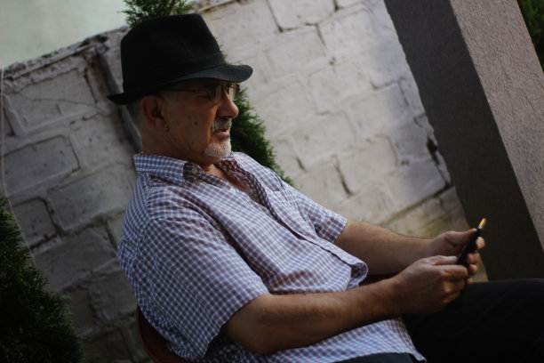 一位戴眼镜的老人用手触摸手机屏幕图片下载