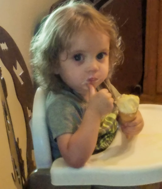 蹒跚学步的孩子在吃冰淇淋蛋卷图片下载