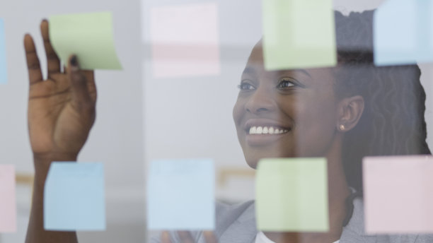 黑人女商人把便利贴贴在办公室的玻璃板上图片下载