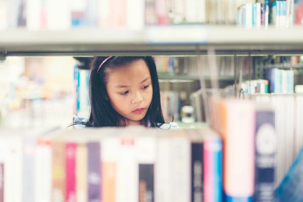 亚洲女学生妇女寻找书在图书馆阅读。教育的概念图片下载