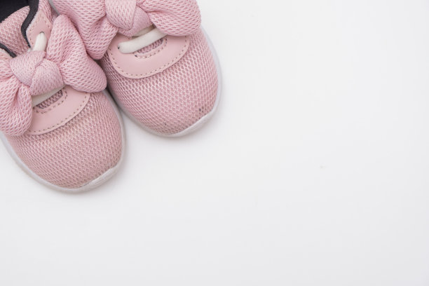 白色背景上的粉色婴儿运动鞋，复制空间图片下载