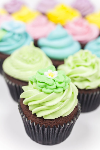 有糖霜或糖霜的巧克力纸杯蛋糕，在白色背景上拍摄粉色、紫色、蓝色、黄色和绿色的照片图片下载