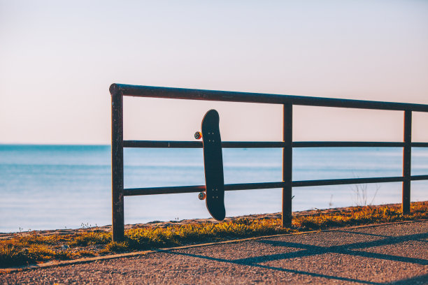 滑板挂在海边的篱笆上图片下载