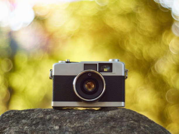 复古的取景器胶片相机与发光的奶油散焦在背景图片下载