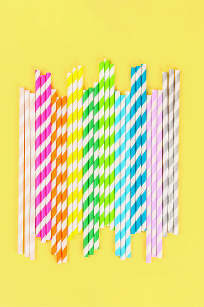 多色草纸管在明亮的黄色柔和的背景。俯视图图片下载